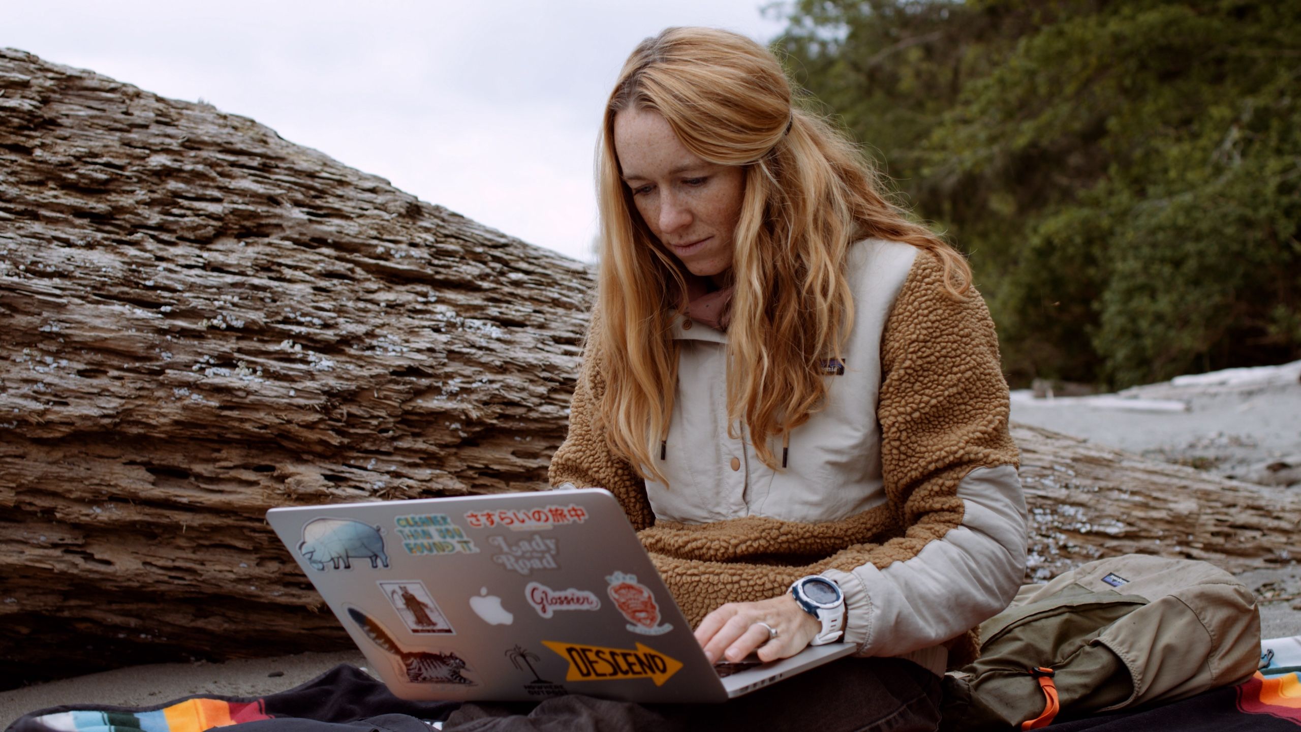 MAK working at her computer on the beach.