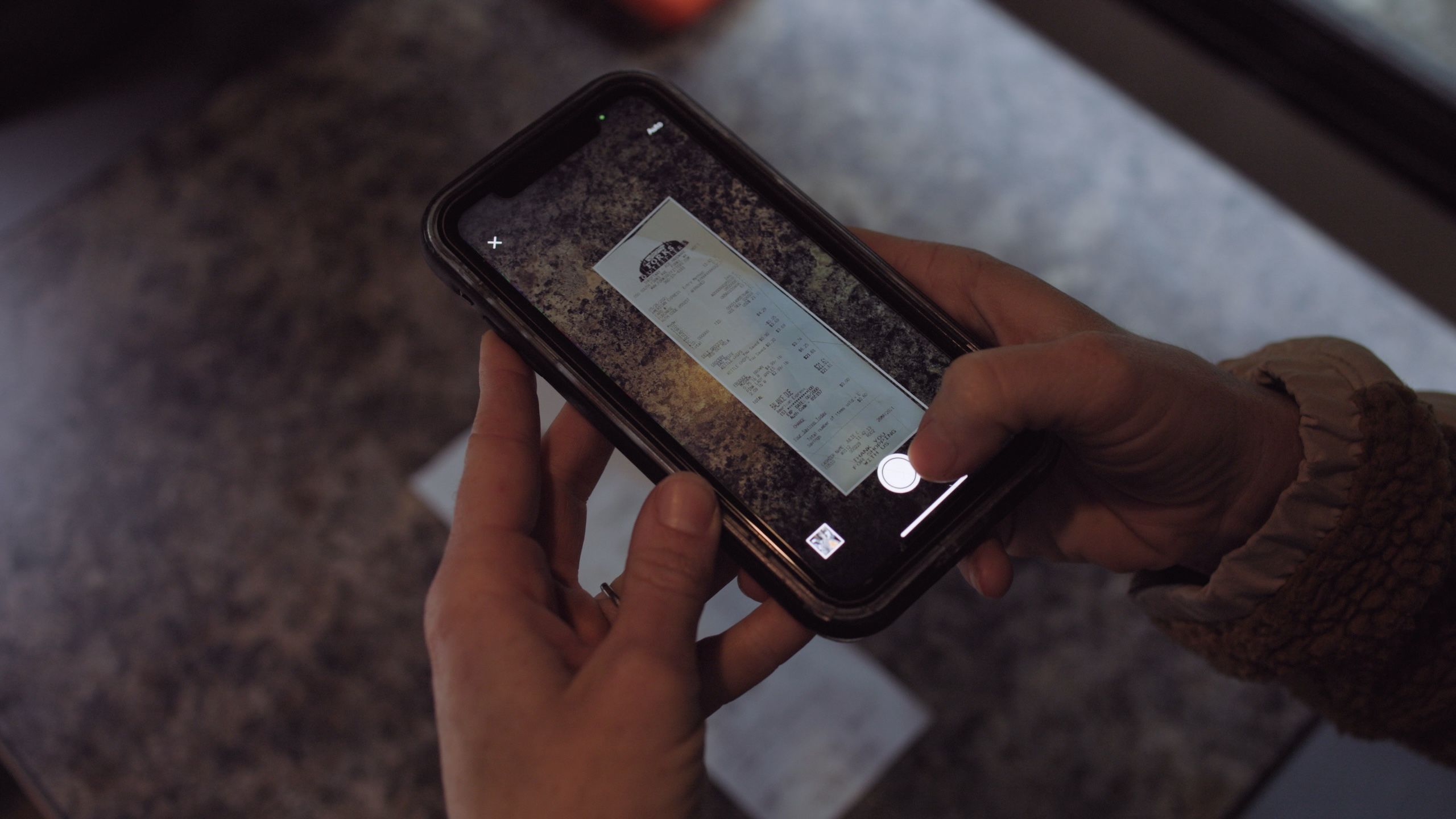 Person using a phone’s camera to scan a reciept into their Dropbox account.