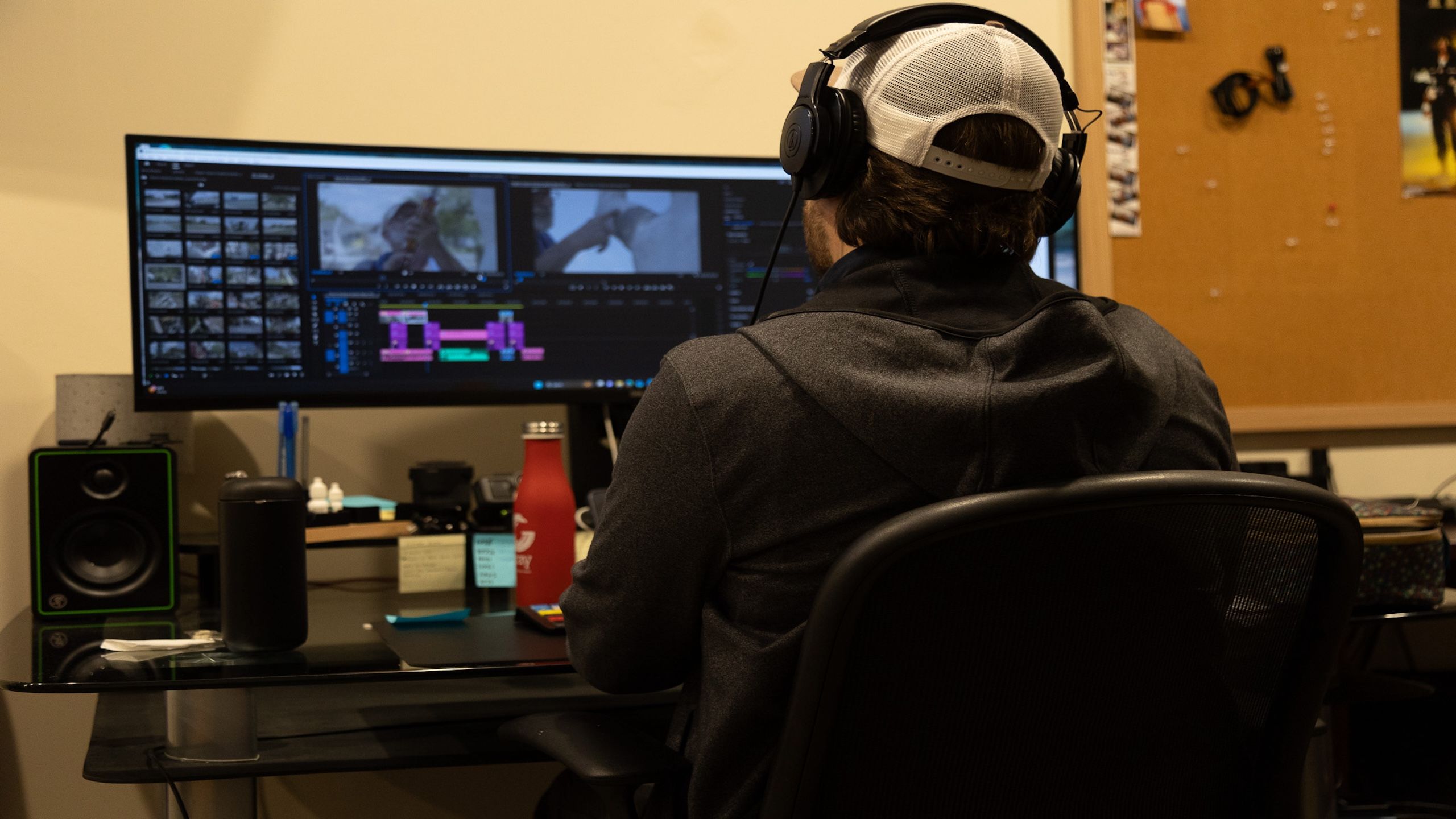 Person editing video on multiple screens