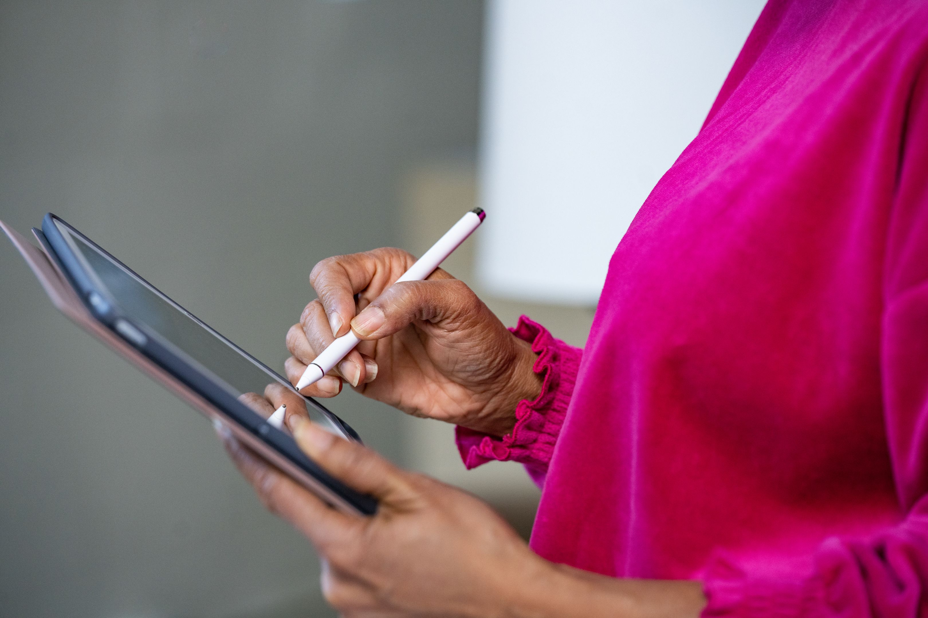 A person works on a tablet with a stylus pen.