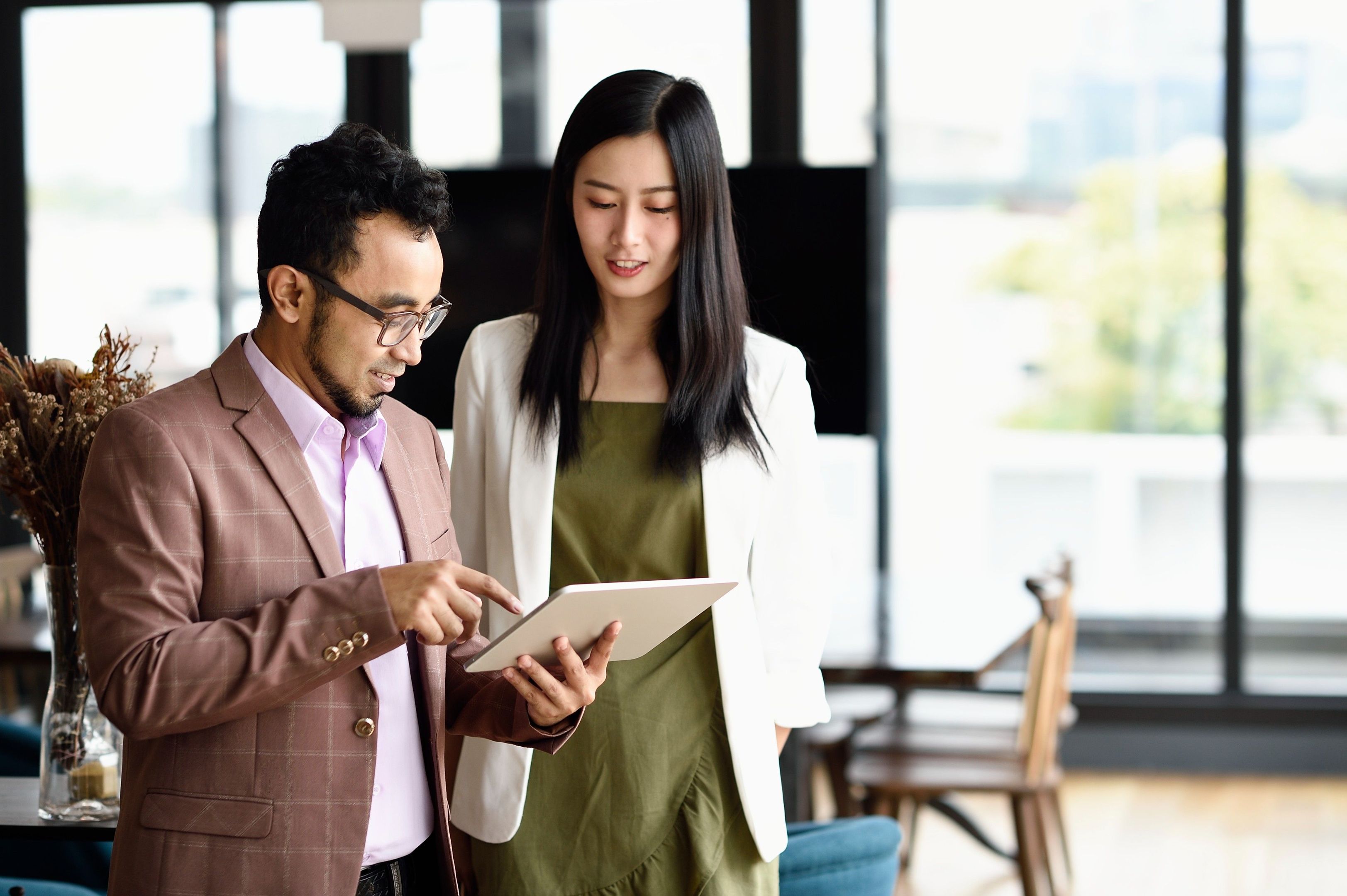 Two professionals looking at a tablet device.