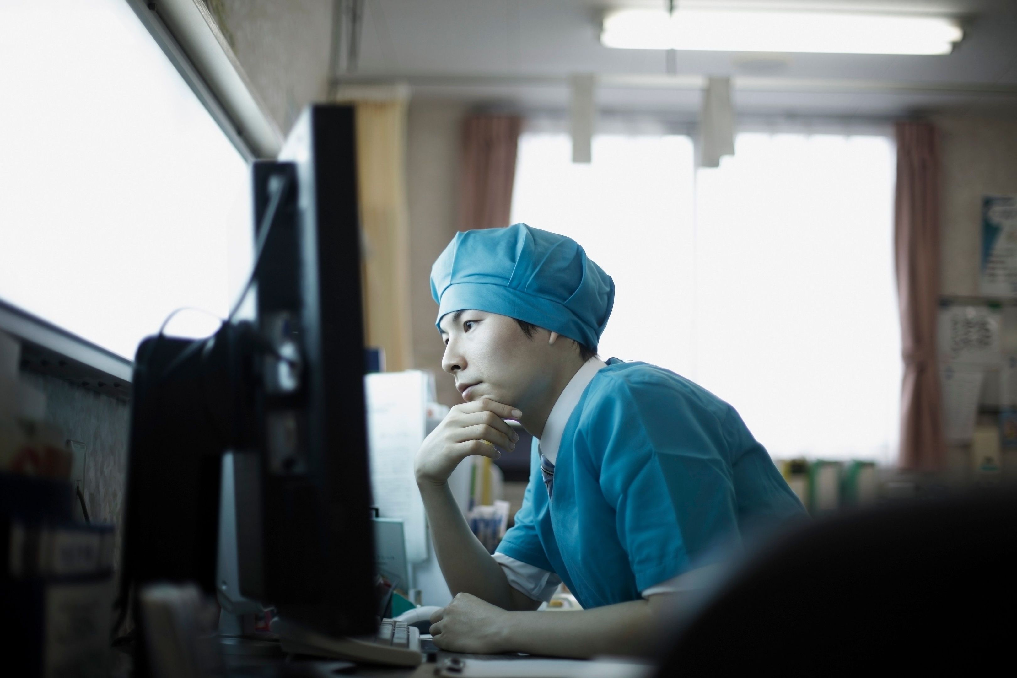 A medical professional works on a computer.