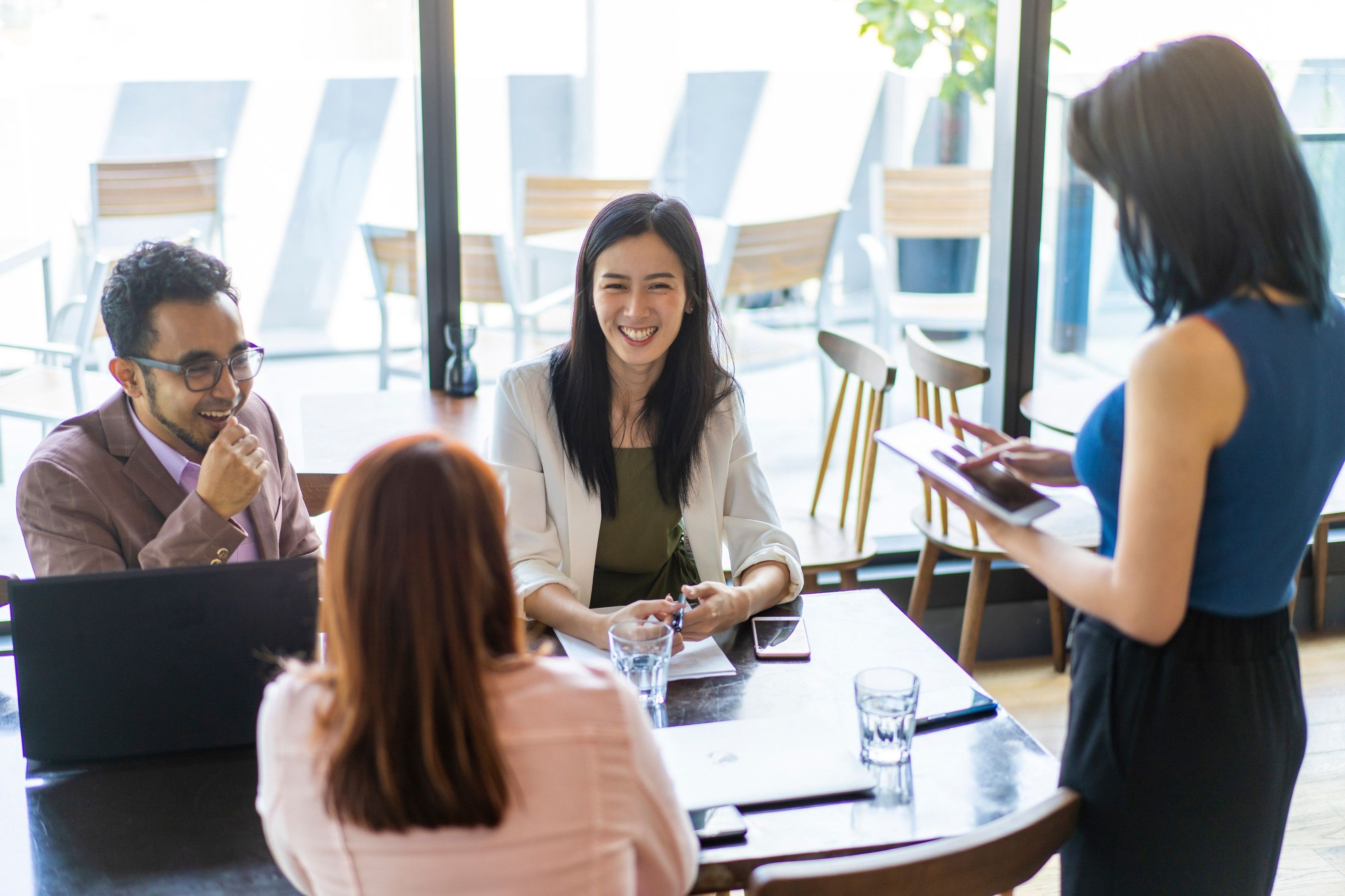 Four people have a discussion around a table.