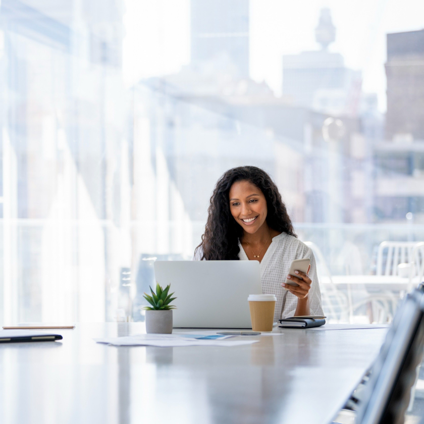 A person in an office smiles at their laptop screen as they figure out how to recover previous versions of their files.